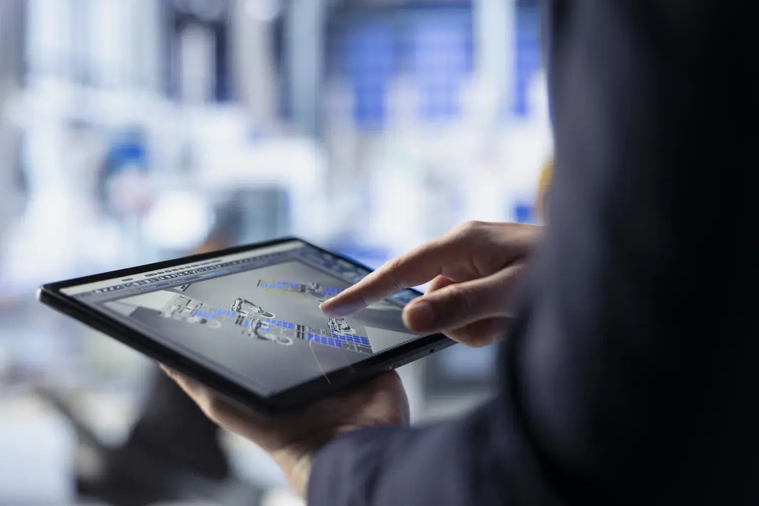 Mitarbeiter analysiert Produktions- und Planungsdaten auf einem Tablet