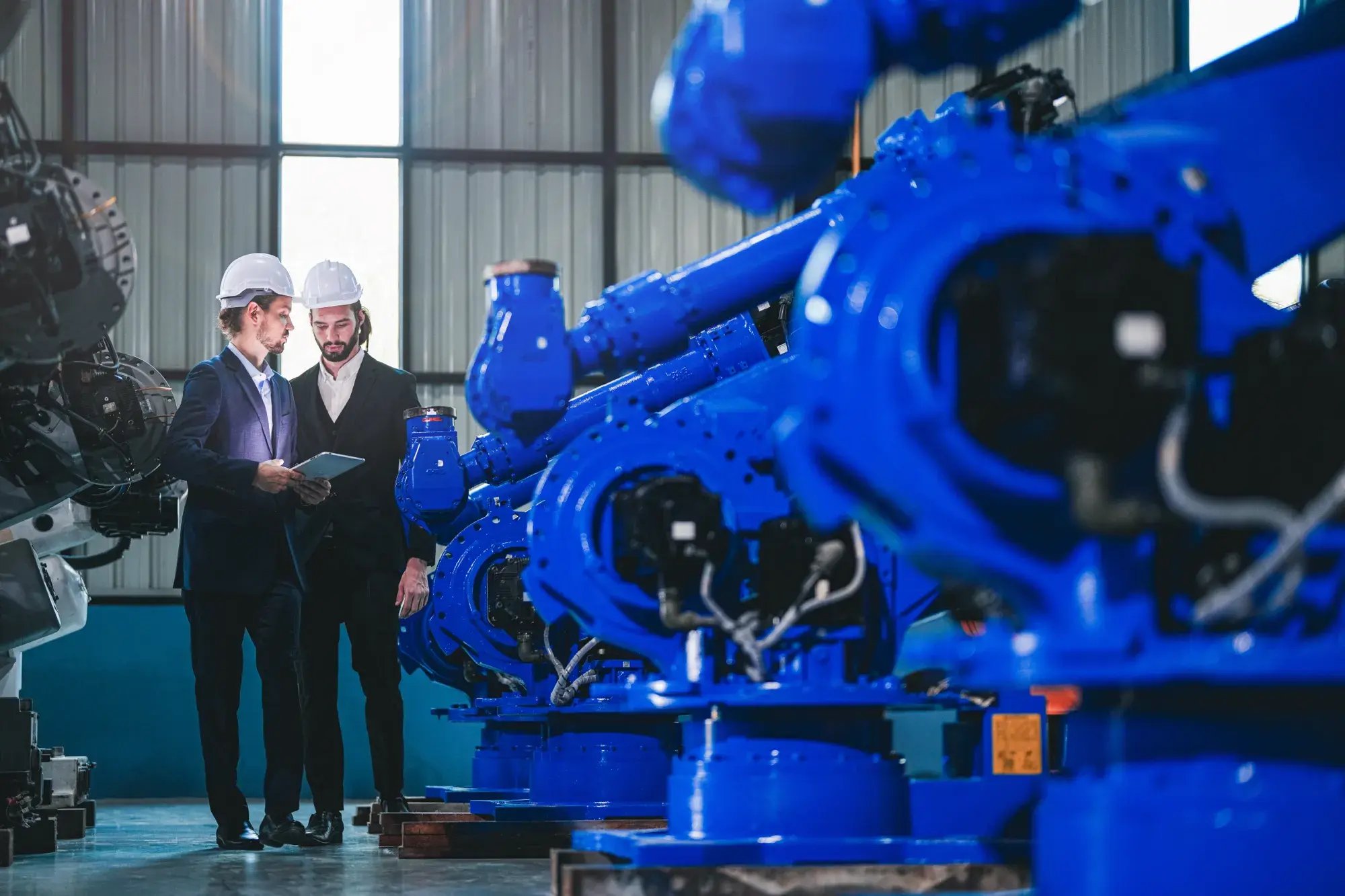 Ingenieure und Produktionsmitarbeiter bei der Abstimmung an einer industriellen Produktionsanlage